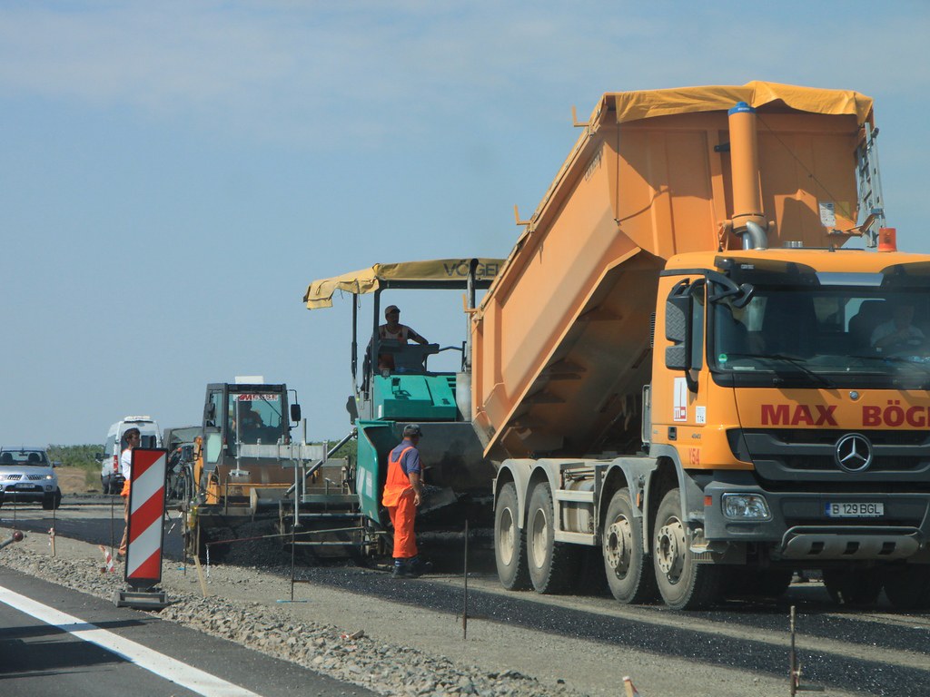Asphalt paver and tipper laying a new bituminous surface