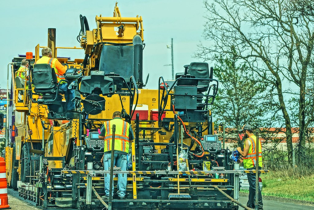 Surfacing crew working behind a paver on a road scheme